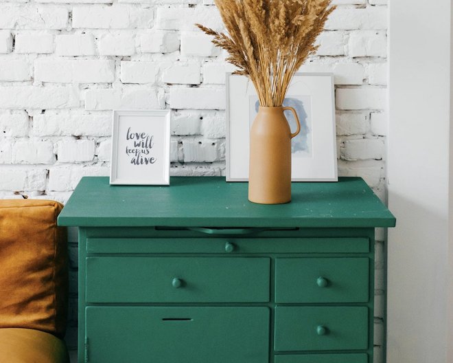 a painted cupboard with a frame and a vase